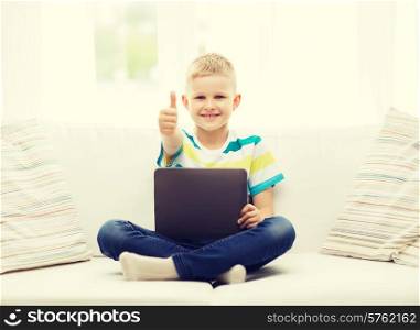 home, leisure and new technology concept - smiling little boy with tablet pc computer at home showing thumbs up