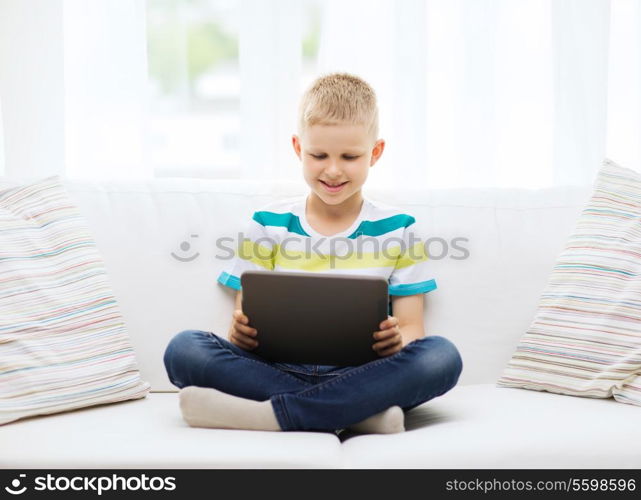 home, leisure and new technology concept - smiling little boy with tablet pc computer at home