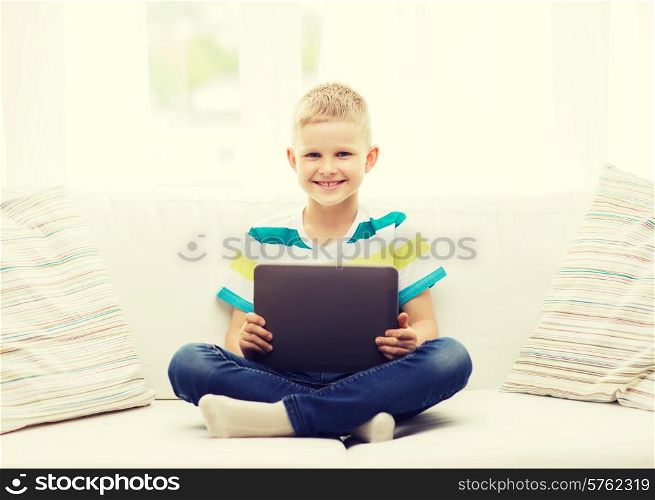 home, leisure and new technology concept - smiling little boy with tablet pc computer at home