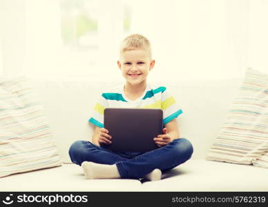 home, leisure and new technology concept - smiling little boy with tablet pc computer at home