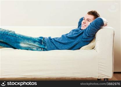 Home, leisure concept. Young handsome man relaxing on couch laying and dreaming