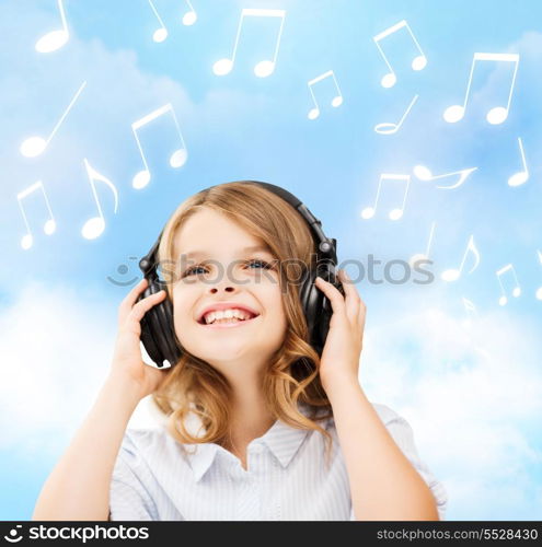 home, leisure, new technology and music concept - smiling little girl with headphones over blue sky background and music notes