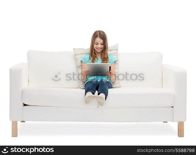home, leisure, technology and happiness concept - smiling little girl sitting on sofa with tablet pc computer