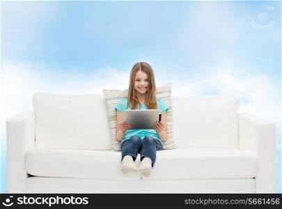 home, leisure, technology and happiness concept - smiling little girl sitting on sofa with tablet pc computer