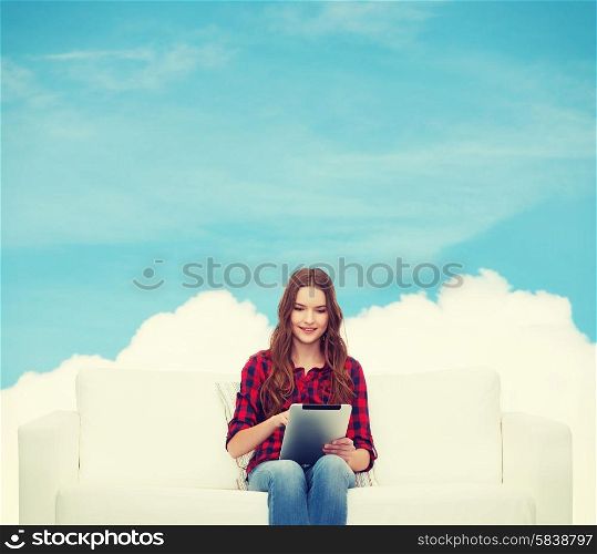 home, leisure, technology and happiness concept - smiling teenage girl sitting on sofa with tablet pc comuter