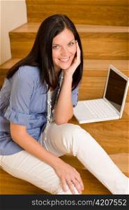 Home living happy woman with laptop sitting on stairs