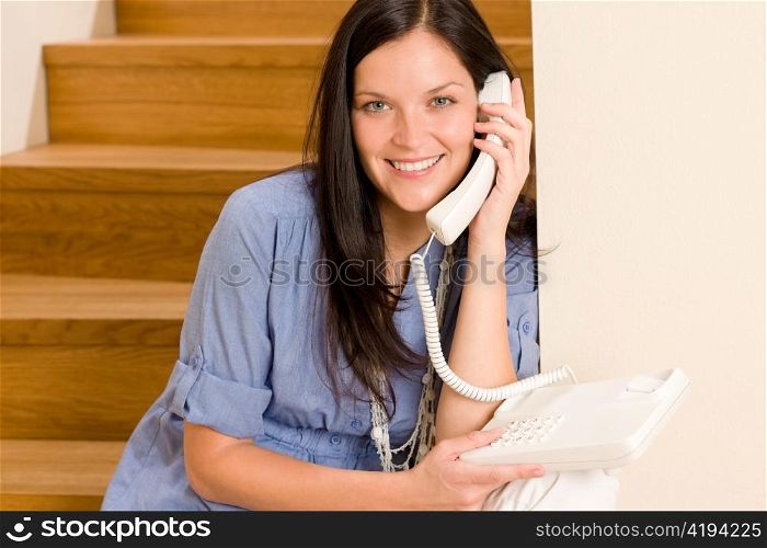 Home living happy young woman calling phone sitting on staircase
