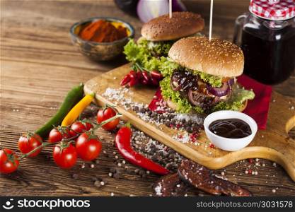Home made burgers on wooden background. Closeup of homemade hamburger with fresh vegetables
