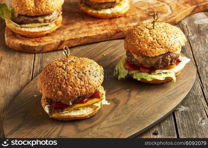 Home made cheeseburgers on rustic wooden table