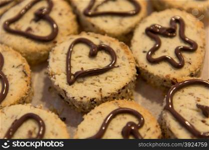Home made cookies. Home made cookies on baking paper with chokolate hearts