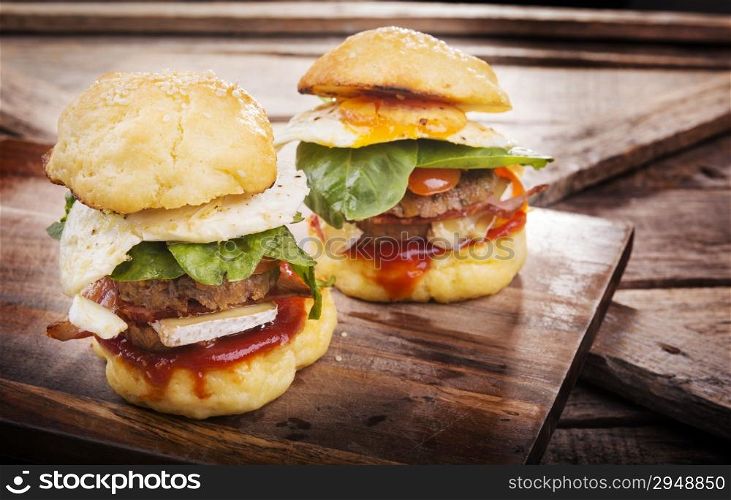 Home made gluten free mini burgers or sliders with beef, egg, lettuce, cheese and sauce