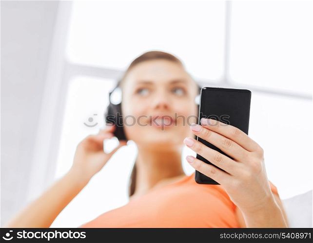 home, music, internet and shopping - woman with headphones and smartphone at home