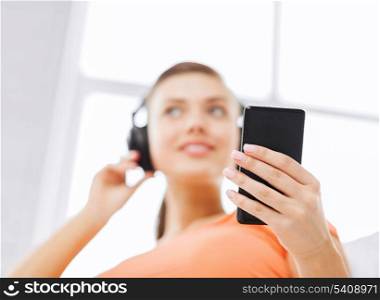 home, music, internet and shopping - woman with headphones and smartphone at home
