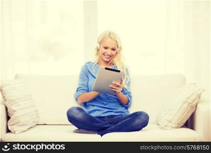 home, music, technology and internet concept - smiling woman lying on the couch with tablet pc computer and headphones at home