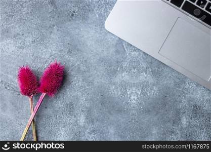 Home office table desk workspace with laptop decorated with red flower