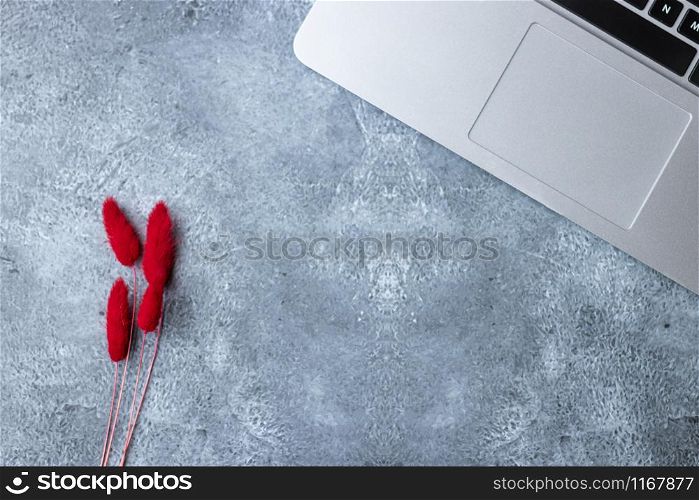 Home office table desk workspace with laptop decorated with red flower