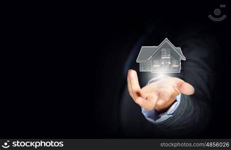 Home on hand. Close up of businessman hand holding house model