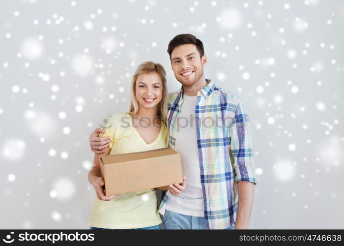 home, people, delivery, and real estate concept - smiling couple with big cardboard boxes moving to new place over snow