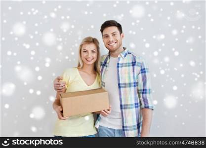 home, people, delivery, and real estate concept - smiling couple with big cardboard boxes moving to new place over snow