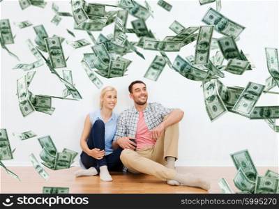 home, people, moving, finances and real estate concept - happy couple of man and woman sitting on floor and dreaming at new place over dollar money falling from above