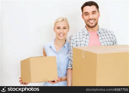 home, people, repair and real estate concept - happy couple holding cardboard boxes and moving to new place