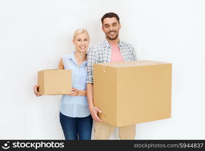 home, people, repair and real estate concept - happy couple holding cardboard boxes and moving to new place