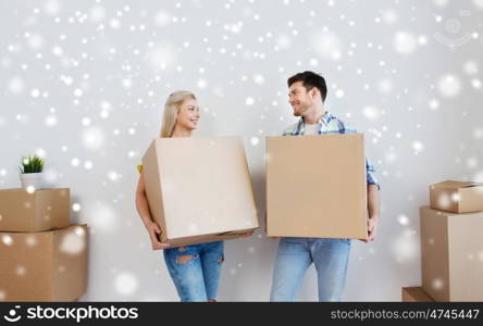 home, people, repair and real estate concept - smiling couple with big cardboard boxes moving to new place over snow