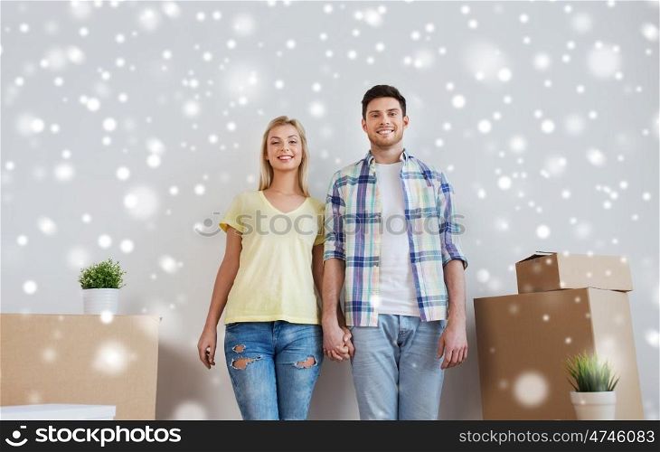 home, people, repair and real estate concept - smiling couple with big cardboard boxes moving to new place over snow
