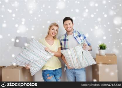 home, people, repair and real estate concept - smiling couple with big cardboard boxes, pillows and other stuff moving to new place over snow