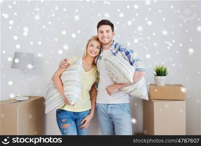 home, people, repair and real estate concept - smiling couple with big cardboard boxes, pillows and other stuff moving to new place over snow
