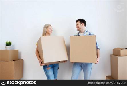 home, people, repair and real estate concept - smiling couple with big cardboard boxes moving to new place