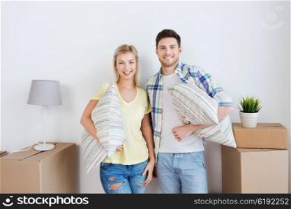 home, people, repair and real estate concept - smiling couple with big cardboard boxes and stuff moving to new place