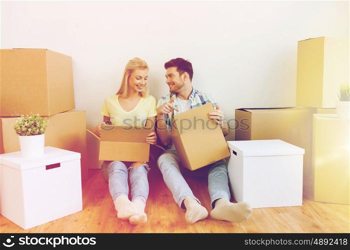home, people, repair and real estate concept - smiling couple with many cardboard boxes moving to new place