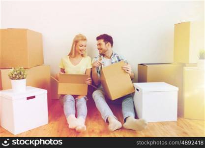 home, people, repair and real estate concept - smiling couple with many cardboard boxes moving to new place