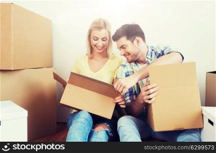home, people, repair and real estate concept - smiling couple with many cardboard boxes moving to new place. smiling couple with many boxes moving to new home