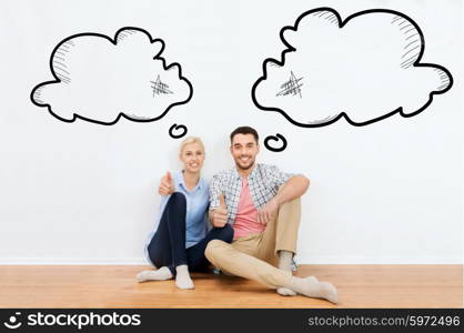 home, people, repair, moving and real estate concept - happy couple sitting on floor and showing thumbs up at new place with empty blank text bubbles