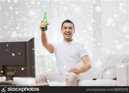 home, people, technology and entertainment concept - smiling man with remote control watching tv and drinking beer at home over snow effect