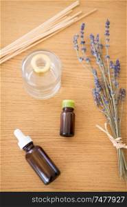 home perfume and aromatherapy concept - aroma reed diffuser, essential oil and bunch of lavender on wooden table. aroma reed diffuser, essential oil and lavender