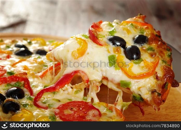 home pizza with tomato and eggplant Closeup .taking slice of pizza,melted cheese dripping