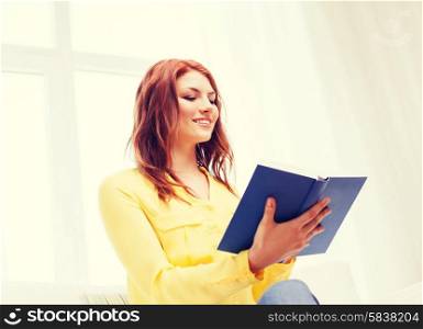 home, reading and education concept - young woman reading book at home