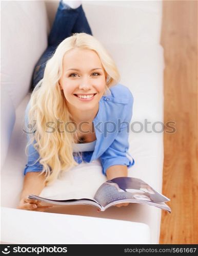 home, reading and leisure concept - smiling woman lying on couch and reading magazine at home