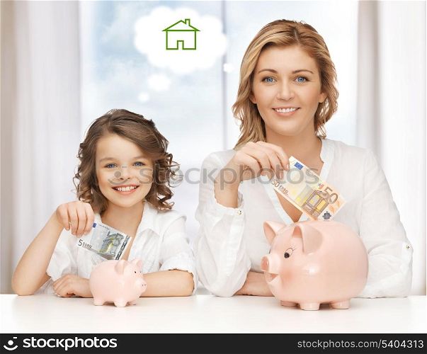 home, real estate and family concept - mother and daughter saving money for new house