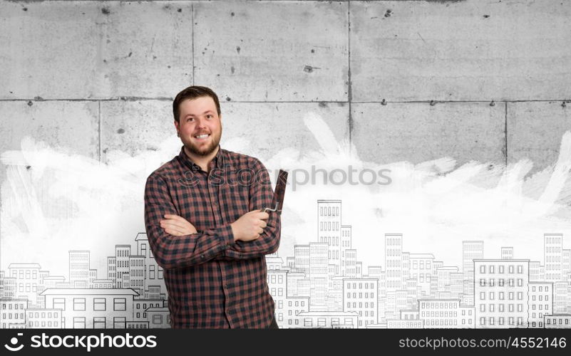 Home renovation and improvement. Man in checked shirt indoors with spatula in hand