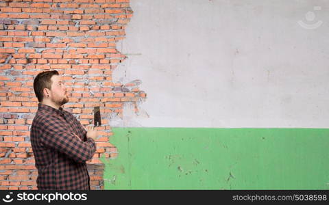 Home renovation and improvement. Man in checked shirt indoors with spatula in hand