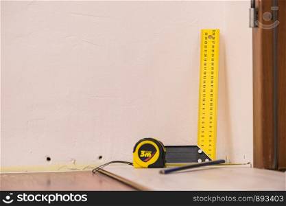 Home renovation concept. Working diy tools. Industrial ruler yellow tape measure, floor panels.. Renovations tools, tape measure, industrial ruler