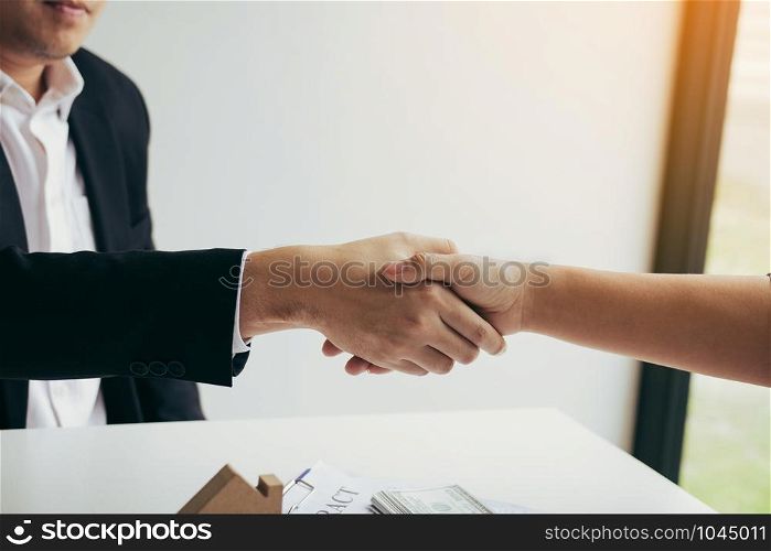 Home sales agents and buyers work on signing new homes and shaking hands.