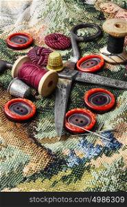 Home sewing accessories. Composition with tailor scissors,sewing threads and buttons from clothing