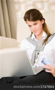 Home shopping - woman with credit card and laptop in lounge