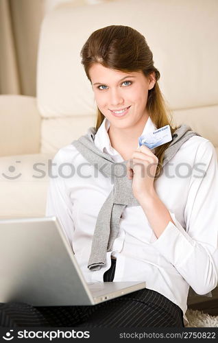 Home shopping - woman with credit card and laptop in lounge