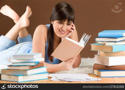 Home study - woman teenager read book lying on wooden floor